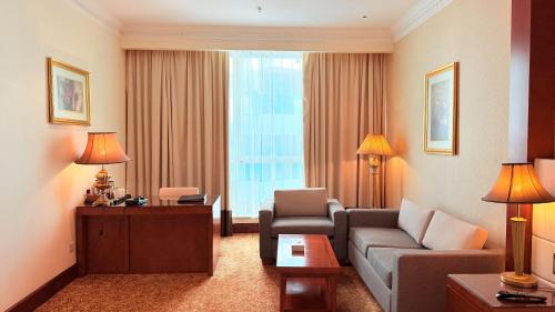a living room with a couch and chairs in a hotel room at Sunday Hotel Al Barsha Dubai Mall of the Emirates Formerly Grand Excelsior Al barsha in Dubai