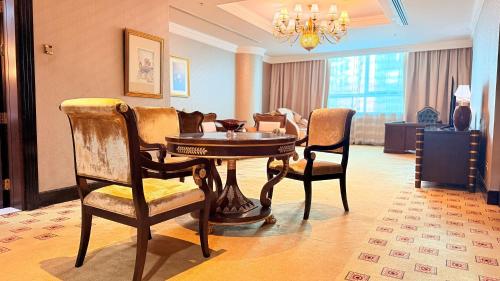 a living room with a table and chairs at Sunday Hotel Al Barsha Dubai Mall of the Emirates Formerly Grand Excelsior Al barsha in Dubai