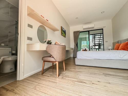 a bedroom with a bed and a mirror and a chair at Gaia Pool Villa Khao Yai in Ban Bung Toei