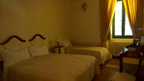 a hotel room with two beds and a window at Antichi Feudi Dimora D'Epoca in Teggiano