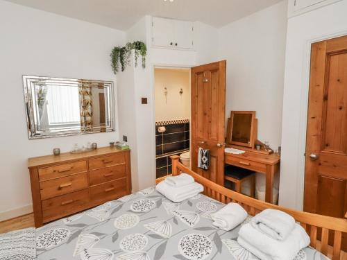a bedroom with a bed and a desk and a television at Sea Mist in Newbiggin-by-the-Sea