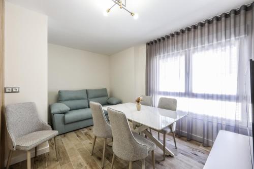 a living room with a table and chairs and a couch at Polán Living | New Apartment - B in Polán
