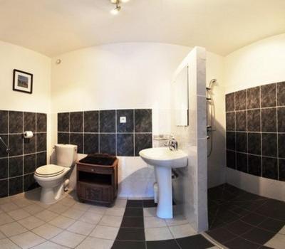 a bathroom with a toilet and a sink and a tub at Gite de la Mare de la Trémaillerie in Blainville-sur-Mer