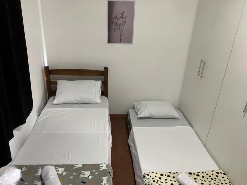 a small room with two beds in it at Panamá 90 - 21 - Região Central in Poços de Caldas