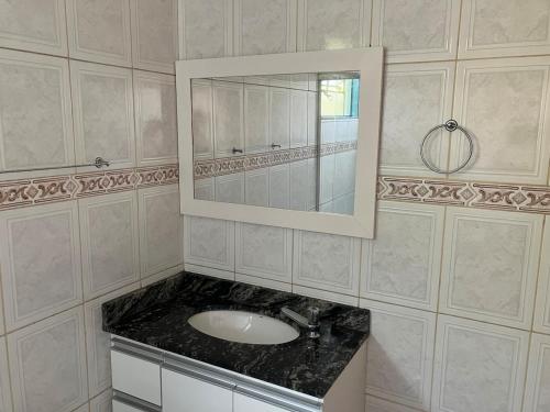a bathroom with a sink and a mirror at Panamá 90 - 21 - Região Central in Poços de Caldas