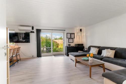 a living room with a couch and a table at House near public transport in Lystrup