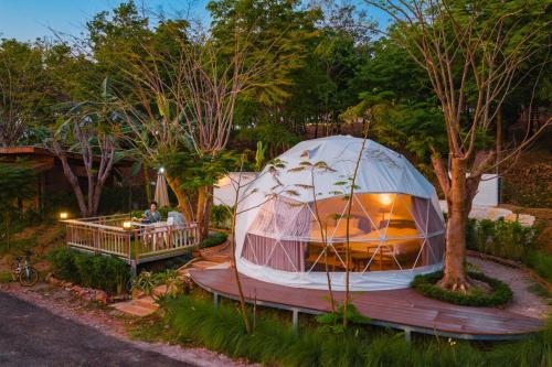 a large tent sitting on a wooden deck in a garden at PhuKasa Valley Maesot -Wellness Resort in Ban Mae Kasa