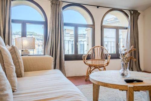 a living room with arched windows and a table at Flateli Santa Clara 22 in Girona