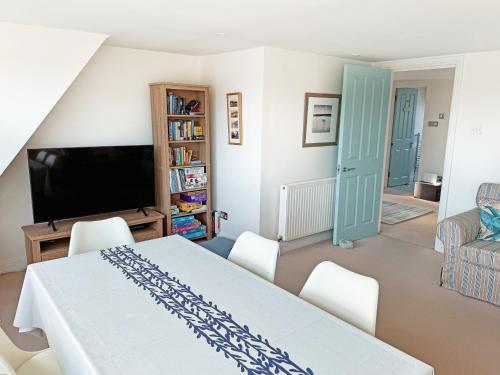 a living room with a table and chairs and a tv at Sandbourne in Bournemouth