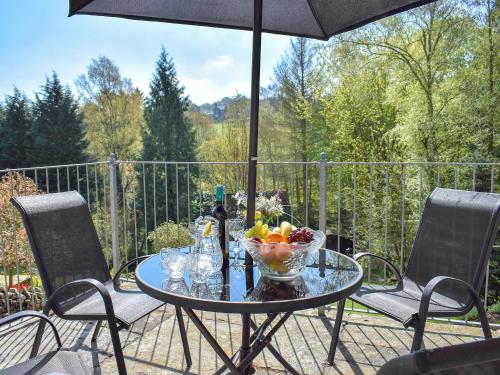 a table with a bowl of fruit and an umbrella at Denham in Glaisdale
