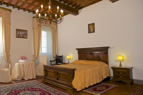 a bedroom with a bed and a chandelier at Anacleto via Castello 48 in Collodi