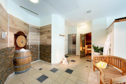 a bathroom with a barrel shower and a bench at das kappel wein gut hotel in Kitzeck im Sausal