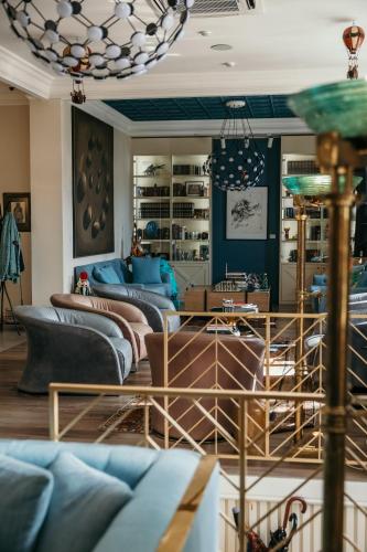 a living room with blue couches and a chandelier at Artist hotel in Subotica
