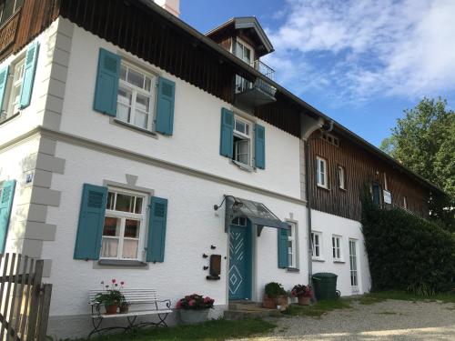 a white house with blue shutters on it at Maisonette Giggi in Peiting