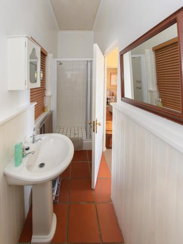a bathroom with a sink and a mirror at Albatross Guest House in Simonʼs Town