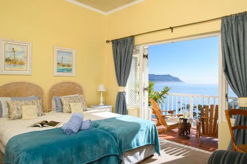 a bedroom with a bed with a view of the ocean at Albatross Guest House in Simonʼs Town