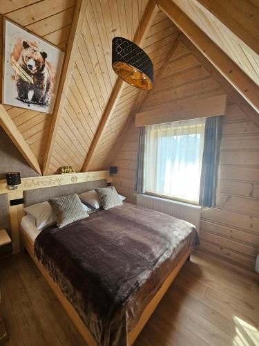 a bedroom with a large bed in a attic at Apartamenty SKUPNIOWY UPŁAZ in Murzasichle