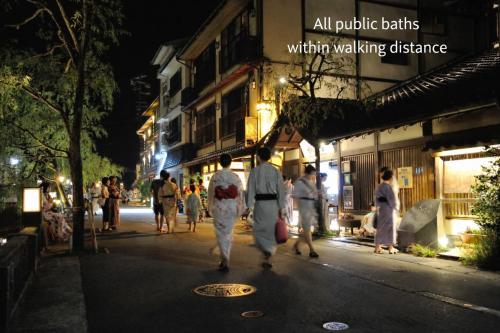 a group of people walking down a street at night at Yoshiharu in Toyooka