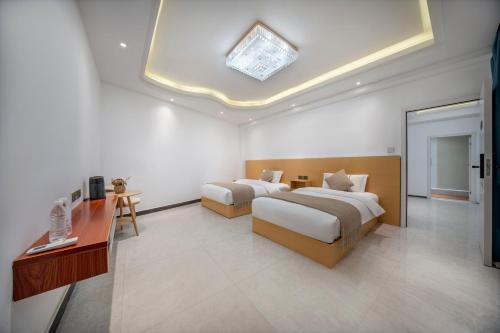 a hotel room with two beds and a television at First encounter with a homestay in Fenghuang County