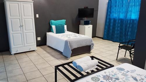 a bedroom with a bed and a table with towels at Siesta Guest House in Musina