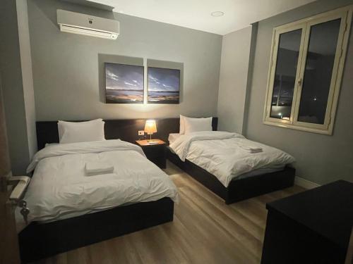 a hotel room with two beds and two windows at Maison 7 Residence in Obour