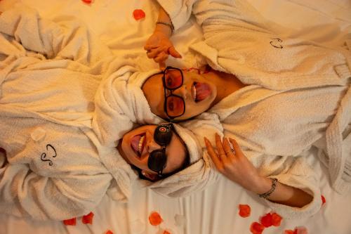 a woman laying on a bed wearing sunglasses at Hesperia Suite - Jacuzzi & Garden in Corigliano dʼOtranto
