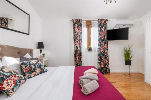 a bedroom with a white bed with a red blanket at House with pool and whirlpool in Sarići