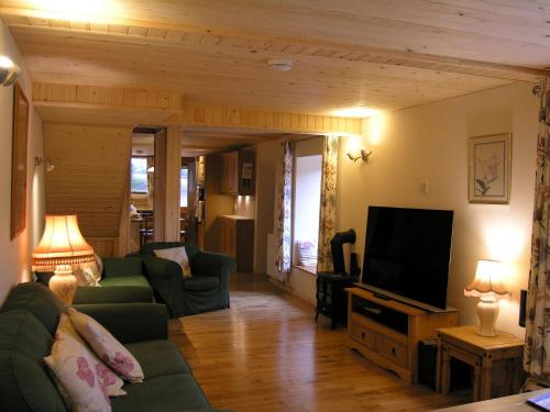 a living room with a couch and a television at Selworthy- Ukc4915 in Timberscombe