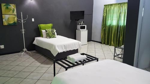 a room with two beds and a television in it at Siesta Guest House in Musina