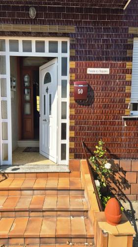 a brick house with a white door and a brick wall at Fogar do Faustino,Rianxo by Cristian&Tamara "alquileres" in Rianjo