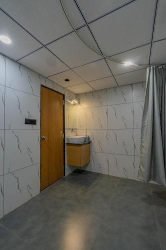 a room with a bathroom with a sink and a door at hotel monville akota in Vadodara