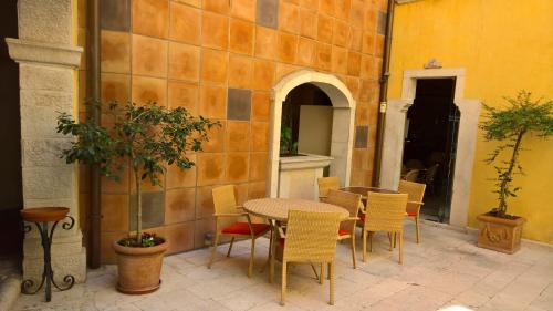 a patio with a table and chairs in a building at Antichi Feudi Dimora D'Epoca in Teggiano