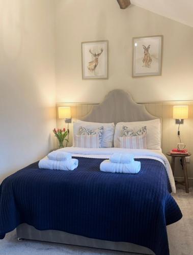 a bedroom with a large bed with blue sheets and pillows at Bents Holiday Cottage, Views & Parking for two cars in Oxenhope
