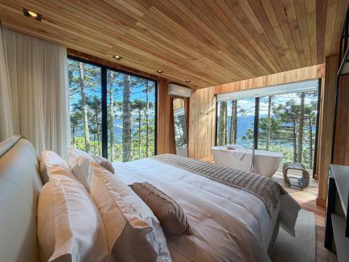 a bedroom with a large bed and a large window at Mökki Cabanas de Altitude INAUGURAÇÃO ABRIL 2026 in Urubici