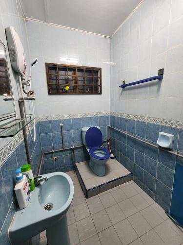 a bathroom with a blue toilet and a sink at Raintown RR Homestay in Kamunting