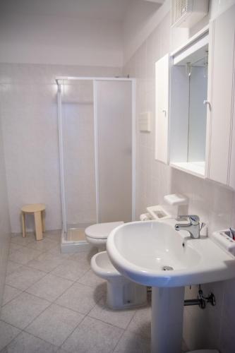 a bathroom with two toilets and a sink and a shower at Appartamenti Bonaventura in Tignale