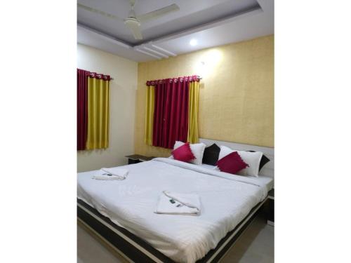 a bedroom with a bed with red and yellow curtains at Green Leaf Mini Resort in Mahabaleshwar