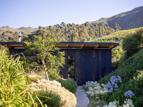 a garden with a wooden pathway leading to a building at Camissa Farm in Stellenbosch