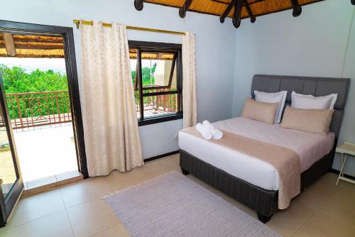 a bedroom with a bed and a large window at The View Guesthouse in Nelspruit
