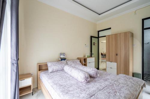 a bedroom with a bed with pillows on it at Spacious Tropical Villa with Pool and Bfast in Sleman