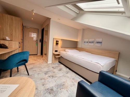 a bedroom with a large bed and a table and chairs at Hotel Schiller in Olching