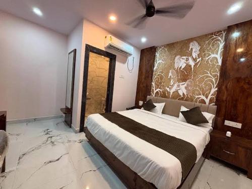 a bedroom with a large bed with a mural on the wall at hotel kargil inn in Satna