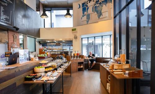 a restaurant with a counter with food on it at Kokotel Bangkok Surawong in Bangkok