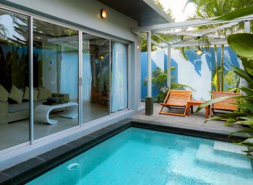 a house with a swimming pool and two chairs at Villa Sonata Phuket in Chalong