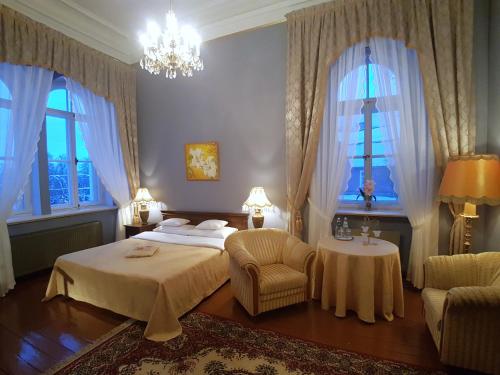 a bedroom with a bed and a chair and windows at Birinu Castle in Bīriņi