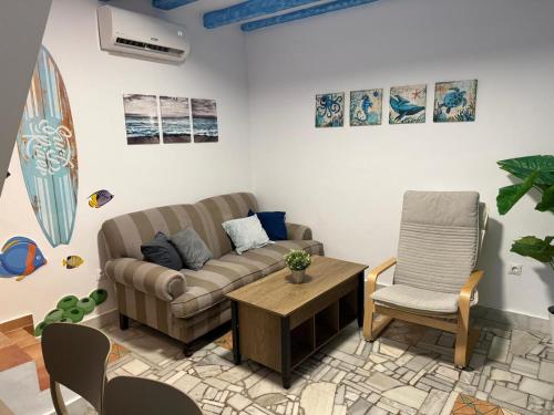 a living room with a couch and a chair at Apartamento Pacífico in Chipiona
