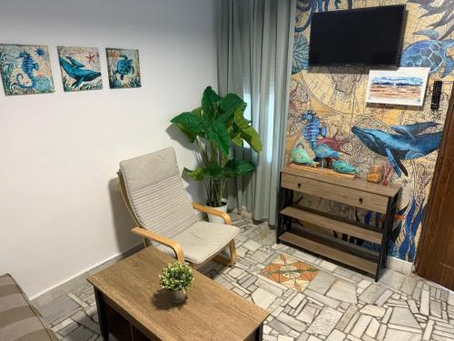 a living room with a tv and a chair at Apartamento Pacífico in Chipiona