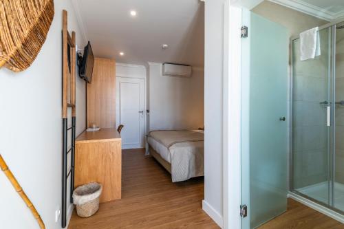 a bedroom with a bed and a glass shower at Vila Sao Vicente Boutique (Adults Only) in Albufeira
