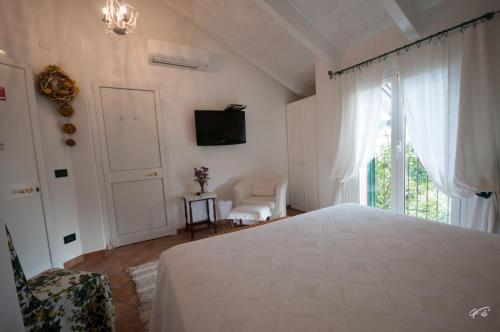 a bedroom with a bed and a tv and a window at Guest House Arancia145 in Ceriale
