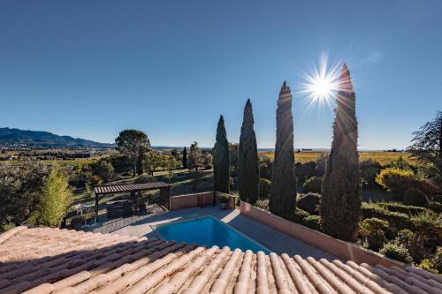 an outdoor swimming pool in a villa with trees at Hotel Bellerive in Rasteau